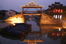 Illuminated bridge reflected in Tongli canal