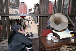Musician looking out on street scene from Nanyuan Tea House, Tongli