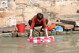 Woman washing clothes in Tongli canal