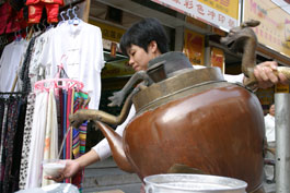 Pouring tea from giant dragon-decorated teapot, Yangshuo